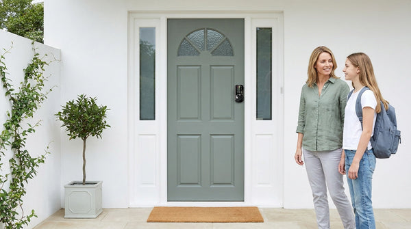 Mother and teen at a grey-green front door with a VE07 fingerprint smart lock - move-in security, keyless entry
