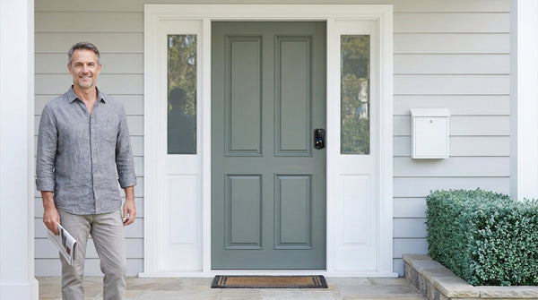 Man beside a grey-green front door with a VE017 keypad smart deadbolt - keypad door lock types and keyless entry